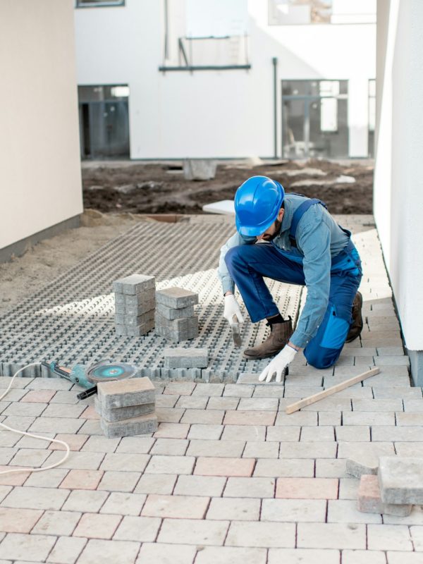 Builder laying paving tiles